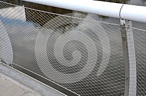 stainless steel mesh stretched on the bridge railing. the lower steel rope serves