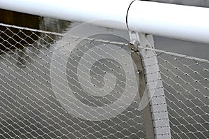 stainless steel mesh stretched on the bridge railing. the lower steel rope serves