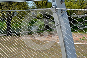 stainless steel mesh stretched on the bridge railing. the lower steel rope serves