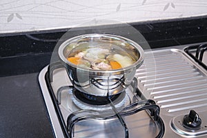 Stainless steel pan with soup on the gas burner stove
