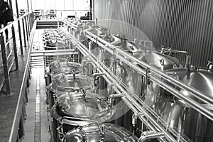 Stainless steel pipes in the factory. Private microbrewery. Modern beer plant with brewering kettles, tubes and tanks