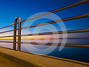 Stainless steel railing sea and coastline in background