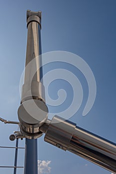Stainless steel railing stairs from the outside of the building on a background of blue sky and beautiful clouds. Pipes, hinges,