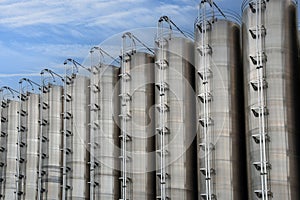 Stainless steel silos against cloudy sky