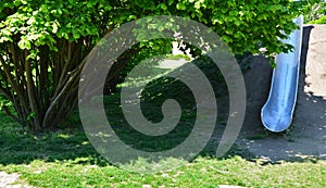 Stainless steel slide on a playground with grassy hills. playground with stone walkways made of natural sandstone stone. a pipelin