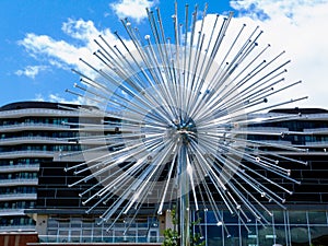 Stainless steel sphere shaped fountain with water pipes under blue sky