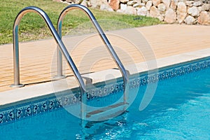 Stainless steel steps leading into swimming pool