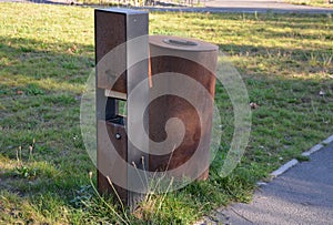 Stainless steel with a surface rusty oxidized layer of rust. On the square in the park, these metal trash cans have bags of dog ex