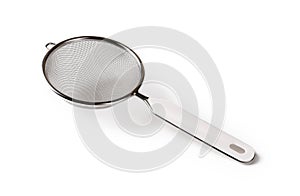 Stainless steel tea strainer with hanging ear isolated on white background. Fine mesh sieve with plastic handle close-up. Modern