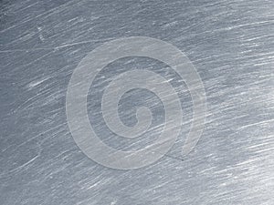 Stainless steel texture with circular scratches.