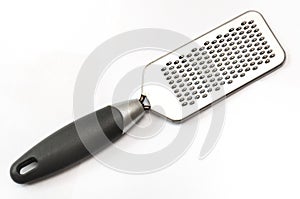 A stainless steel vegetable scraper with black handle