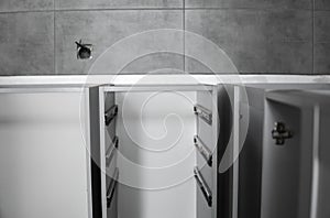 Stainless telescopic bayonet drawer slide guides, installed on a kitchen cabinet from gray chipboard. Accessories for