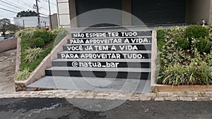 Stair with inscription: NÃÂ£o espere ter tudo para aproveitar a vida. VocÃÂª jÃÂ¡ tem a vida para aproveitar tudo photo