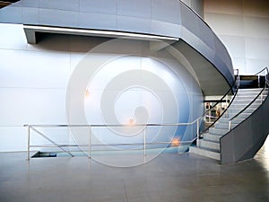 Stair and steel stainless handrail of modern office decoration, grey aluminium composite wall background.