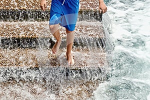 A staircase for bathers in the Atlantic Ocean, a young man jumping down the stairs