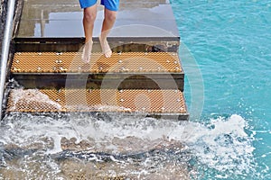 A staircase for bathers in the Atlantic Ocean, a young man jumping down photo