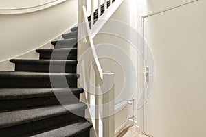 a staircase with black carpeted stairs and white rail