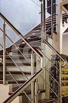 Staircase in a building with a metal shiny balustrade railing