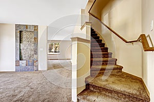 Staircase with carpet steps and wooden railing in empty house
