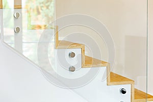 Staircase covered in oak parquet with tempered glass balustrade and chromed pins