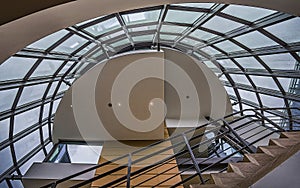The staircase curved skylight of a modern building, made of metal, glass and reinforced concrete.