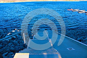 A staircase down into the vast blue lake water