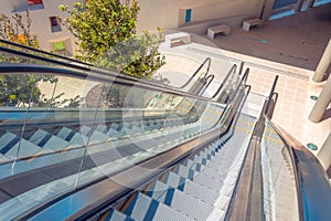 Staircase escalator bottom view on the outside street in the courtyard of the building. Look down descent view