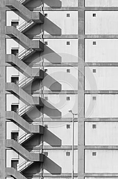 Staircase on exterior of high rise warehouse. Building abstract background in monochrome