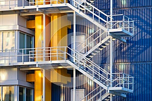 A staircase in a factory. Industrial photography for the background. Manufacturing and manufactory. Bright pipes against a blue wa