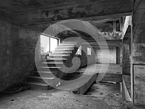 Staircase between floors in an empty messy industrial warehouse, urban exploration of the interior of an abandoned building, with