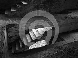 Staircase between floors in an empty messy industrial warehouse, urban exploration of the interior of an abandoned building,