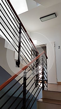 Lviv, Ukraine - 2 2 2020: A staircase with forged cast-iron railings in a modern building illuminated with light from