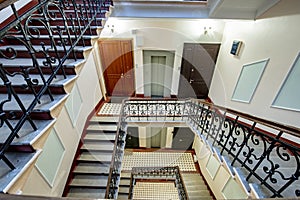 Staircase with forged railings on the railing in the old stairwell photo