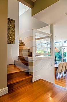 Staircase with hard wood steps to upper level in a luxury suburban home or condominium