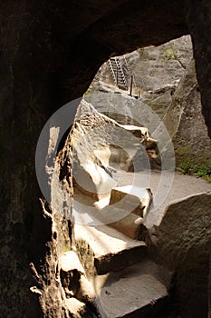 Staircase leading down into stone cave.