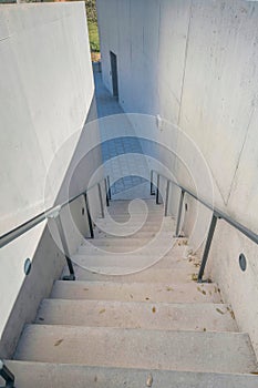 Staircase with metal handrails leading down to a stone tile pavement at Austin, Texas