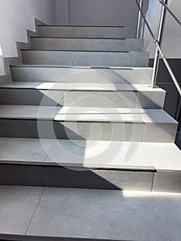 A staircase with a railing and a shadow on the steps