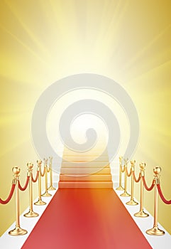 Staircase and red carpet between two gold stanchions with rope