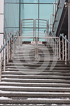 A staircase rising in a modern office building with metal rails on the sides
