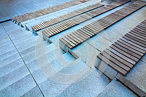 Staircase with seats. Wooden steas on the concrete stairs on outdoor of building