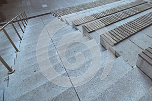 Staircase with seats. Wooden steas on the concrete stairs on outdoor of building