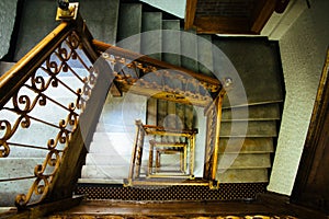 Staircase stairway. Old vintage squared spiral multi-flight stairs stairway with brown wood and metal handrails photo