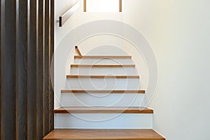 Staircase wooden with wooden handrails on white wall in modern home. Interior structure design concept. Empty pathway of stairway