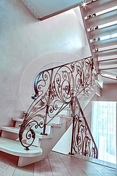 Staircase with wrought iron railing in an empty house