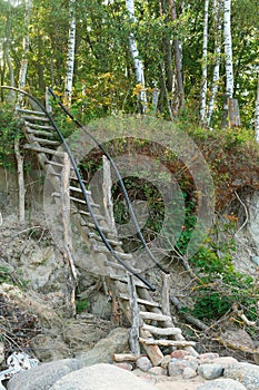 Stairs for descent to the sea, wooden staircase with railing on the slope