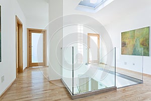 Stairs, glass banister and doors in modern hallway