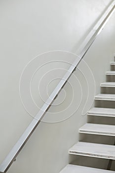 Stairs and hand rails along white wall