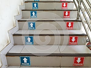 Stairs with Indonesian Writing Stickers "NAIK" and "TURUN" or "Step Up" and "Step Down"