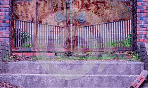 Stairs leading to closed rusted gate