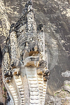 The stairs leading to the entrance are guarded by old large Nagas, mythical snake like creatures at Wat Chedi Luang, Chiang Mai, T